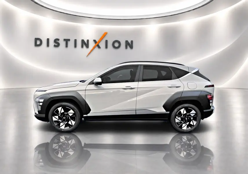 Vue latérale droite d'un Hyundai Kona gris 2025 avec jantes alliage noires et protections d'ailes contrastées.