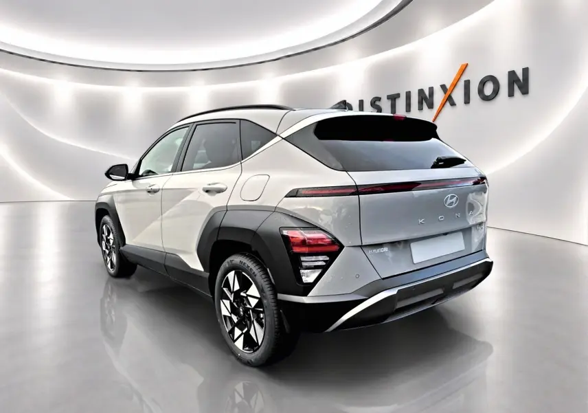 Vue 3/4 arrière droite d'un Hyundai Kona gris 2025 avec jantes alliage et feux arrière LED dans un showroom.