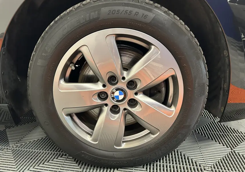 Gros plan sur la jante avant droite en alliage argenté d'une BMW Série 1 noire de 2023 avec pneu Michelin.