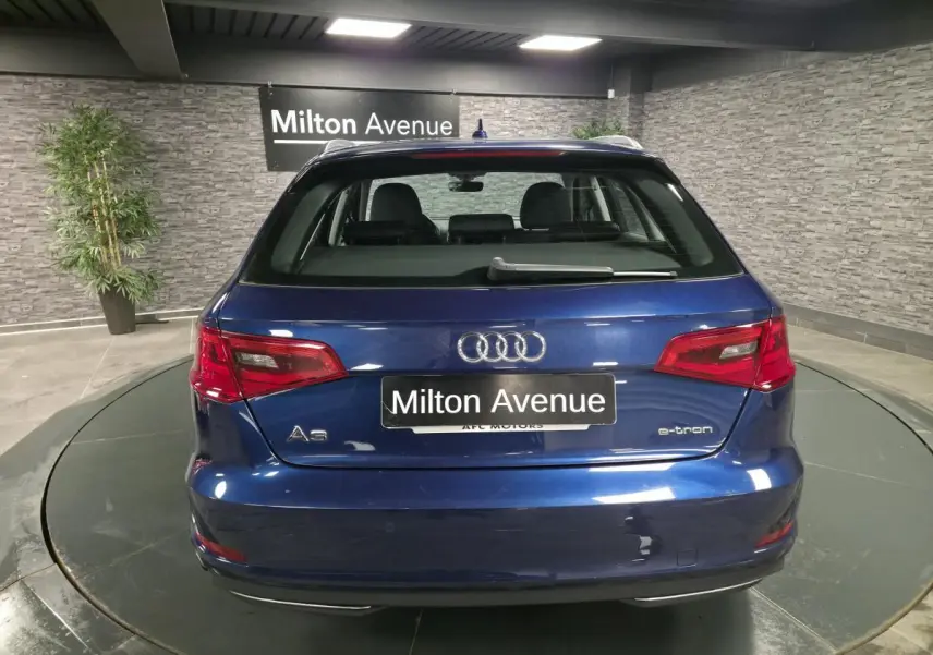 Vue arrière d'une Audi A3 Sportback hybride rechargeable bleu métallisé avec logo e-tron et feux rouges.