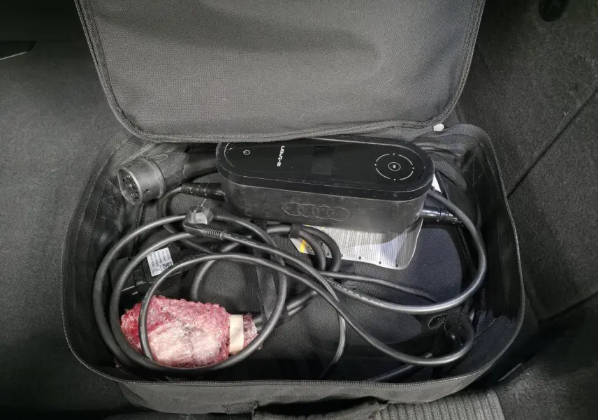 Gros plan sur le câble de recharge e-tron noir rangé dans un sac dans le coffre d'une Audi A3 Sportback bleu.