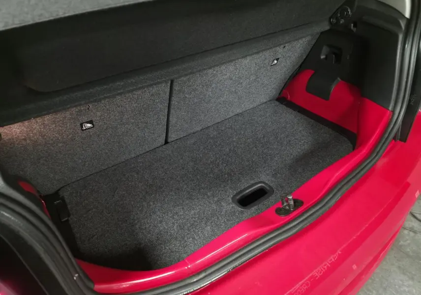 Coffre ouvert vu de dessus d'une Volkswagen Up rouge de 2018 avec habillage gris et rouge visible sur les côtés.