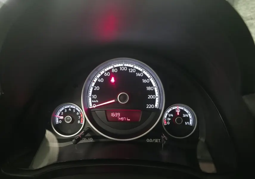 Tableau de bord de Volkswagen UP rouge 2018, vue frontale sur compteurs et affichage numérique rouge.