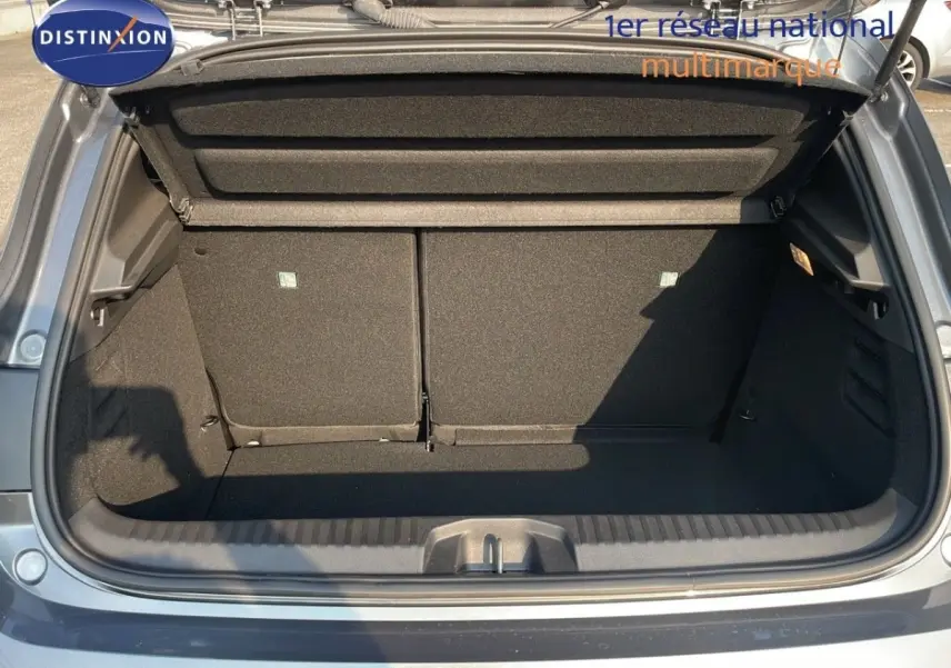 Coffre ouvert vu de l'arrière d'une Renault Clio 2025 gris clair, montrant l'espace de chargement vide.