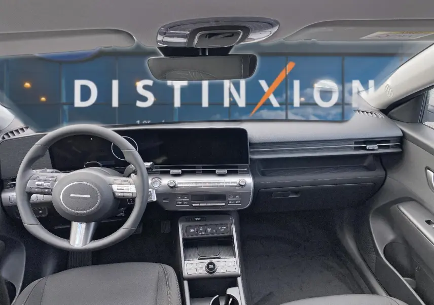Vue intérieure avant du Hyundai Kona gris 2025, mettant en valeur le tableau de bord moderne et le volant multifonction cuir.
