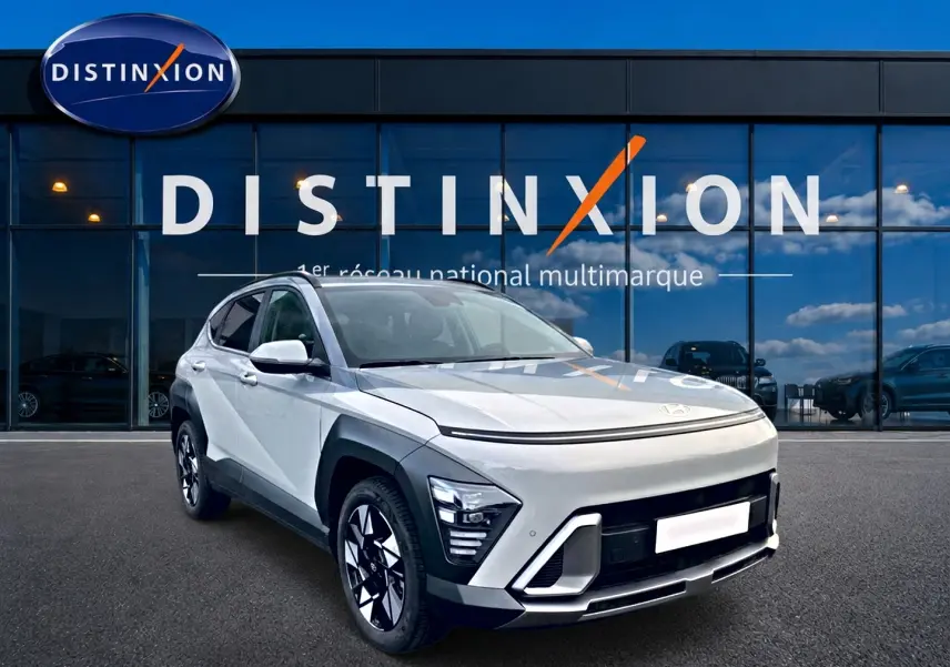 Hyundai Kona gris 2025 en 3/4 avant droit, avec jantes alliage et calandre moderne devant showroom Distinxion.