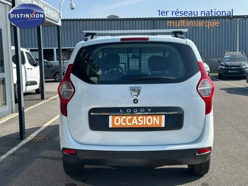 Vue arrière d'un Dacia Lodgy blanc Glacier de 2022 avec plaque "OCCASION" sur parking extérieur.
