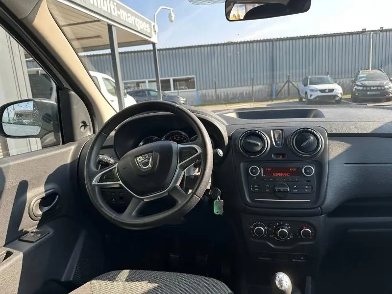 Vue intérieure du tableau de bord et volant du Dacia Lodgy blanc Glacier 2022, avec commandes et radio visibles.