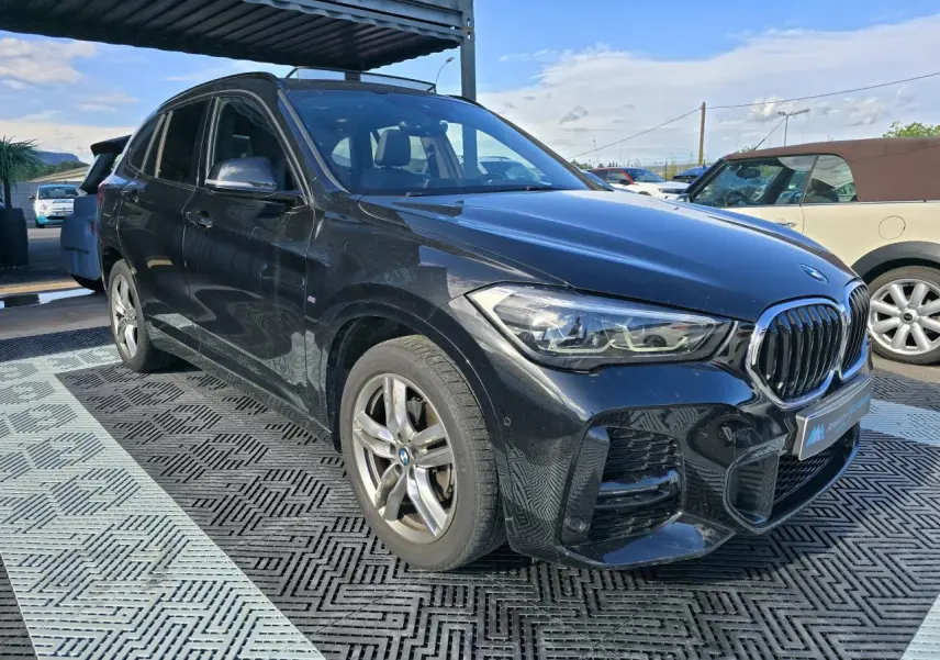 BMW X1 noir saphir métal vue 3/4 avant droit avec calandre Shadow Line et jantes 18 pouces M Sport.
