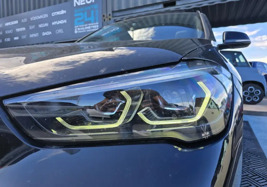 Gros plan sur le phare avant gauche noir saphir métallisé du BMW X1 F48 M Sport 2020 avec éclairage LED distinctif.