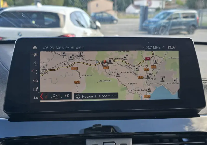 Écran de navigation multimédia BMW X1 F48 affichant une carte routière, vue intérieure avant du tableau de bord.