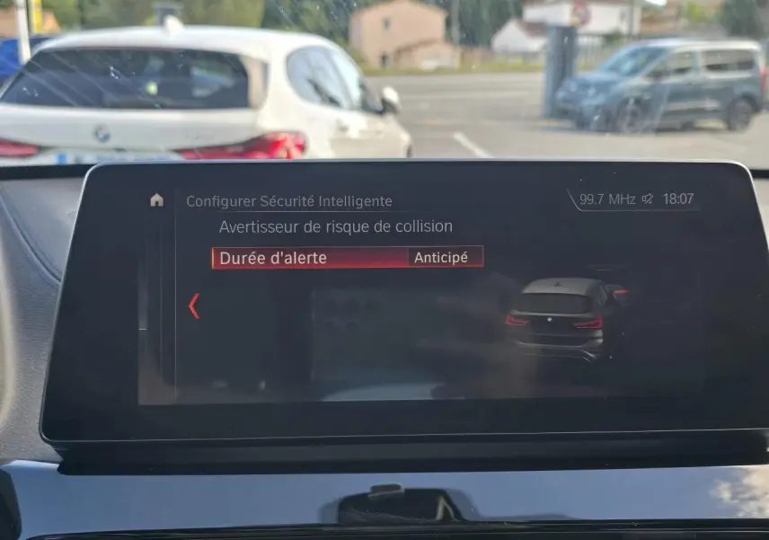 Affichage tête haute montrant un BMW X1 noir saphir métal vu de l'arrière sur l'écran multimédia intérieur.