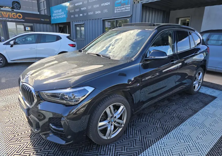 BMW X1 F48 noir saphir métal en 3/4 avant droit avec jantes alliage et calandre chromée brillante