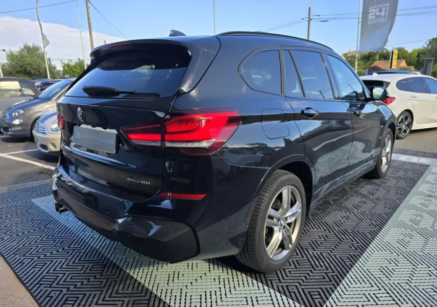 Vue 3/4 arrière droite d'un BMW X1 noir saphir métallisé avec feux arrière LED et jantes alliage 18 pouces.