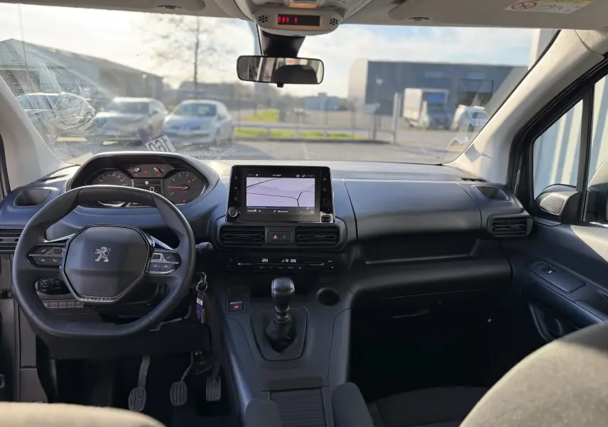 Vue intérieure avant du Peugeot Rifter gris platinium 2020, tableau de bord avec écran tactile et volant multifonction.