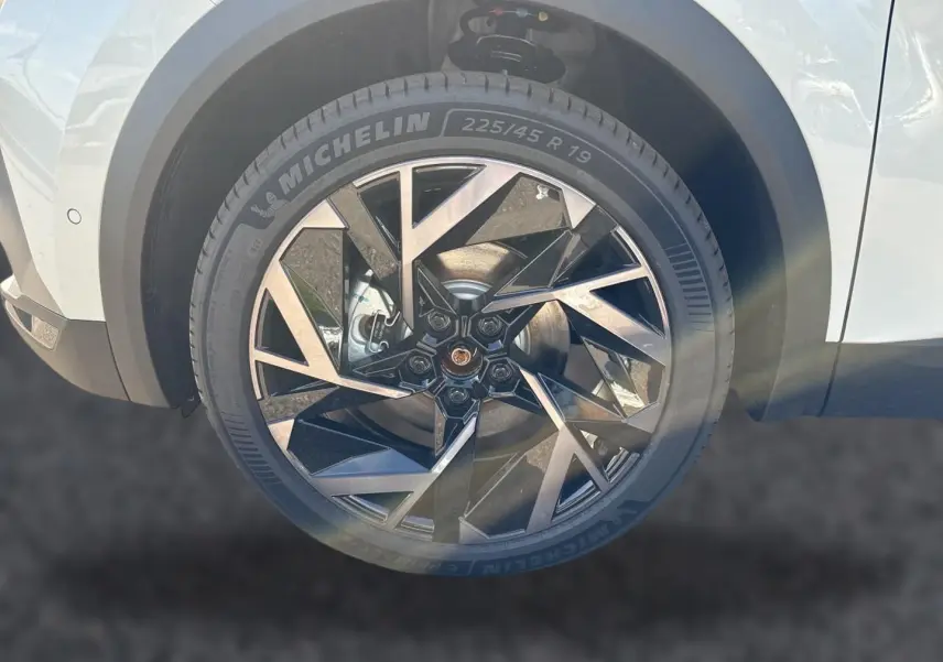Gros plan sur la roue avant droite du Renault Symbioz blanc nacré avec jante alu noire et argentée au design géométrique.