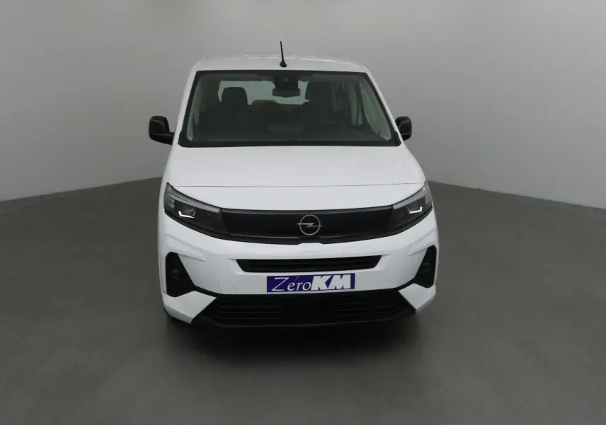 Vue frontale d'un Opel Combo Life blanc avec calandre noire et plaque Zero KM visible.