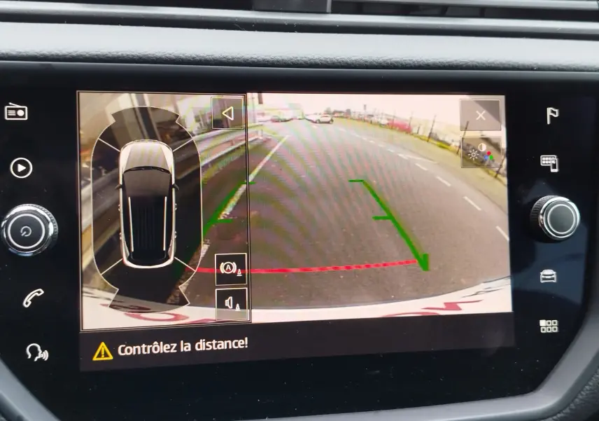 Écran de caméra de recul du SEAT Arona blanc avec toit gris, affichant les lignes de guidage vertes et rouges.