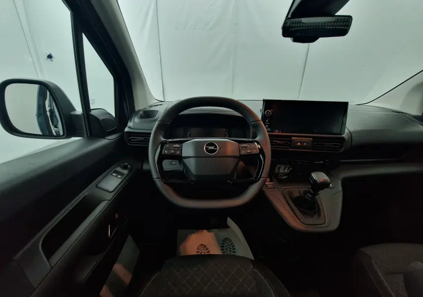 Intérieur de l'Opel Combo Life bleu Kiama, vue frontale du poste de conduite avec volant multifonction et boîte manuelle.