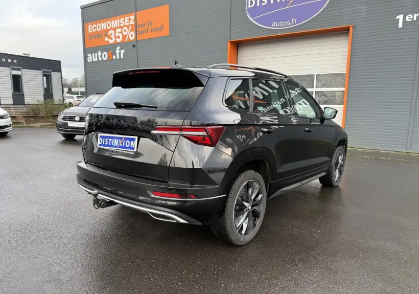 Vue 3/4 arrière droite d'un Skoda Karoq noir Magic nacré avec crochet d'attelage et jantes alliage noires.