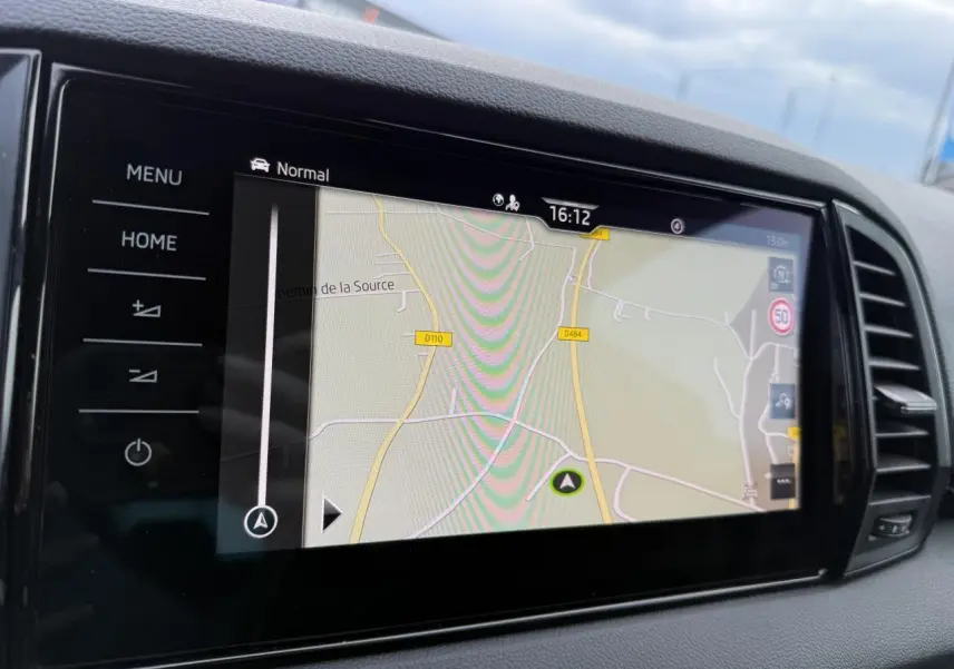 Écran tactile du système de navigation du Skoda Karoq 2.0 TDI Sportline avec interface claire et boutons tactiles noirs.