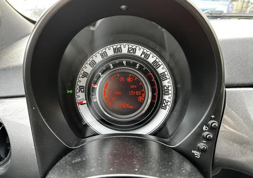 Vue rapprochée du combiné d'instrumentation analogique de la Fiat 500 gris foncé, affichant la vitesse et l'odomètre numérique.