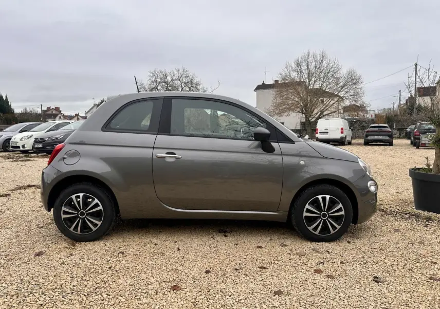 Profil côté gauche de la Fiat 500 gris foncé 2023 avec jantes alliage 15 pouces et rétroviseurs noirs grainés.