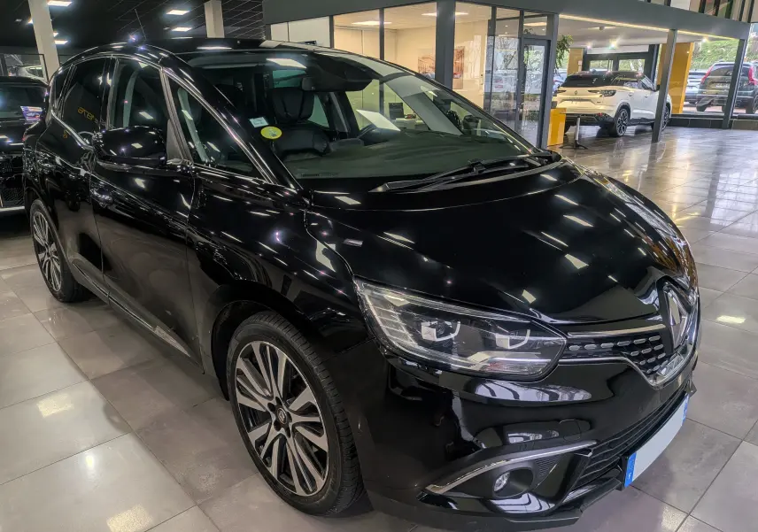 Vue 3/4 avant gauche d’un Renault Scénic IV noir étoilé avec jantes alliage et phares LED dans un showroom.