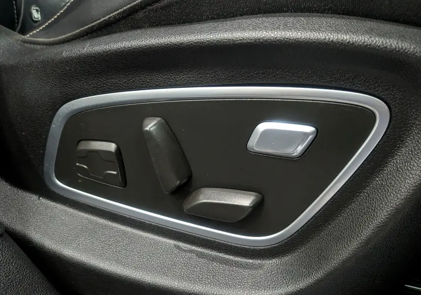 Gros plan sur les commandes électriques de réglage du siège en cuir noir du Renault Scénic IV Initiale Paris 2018.