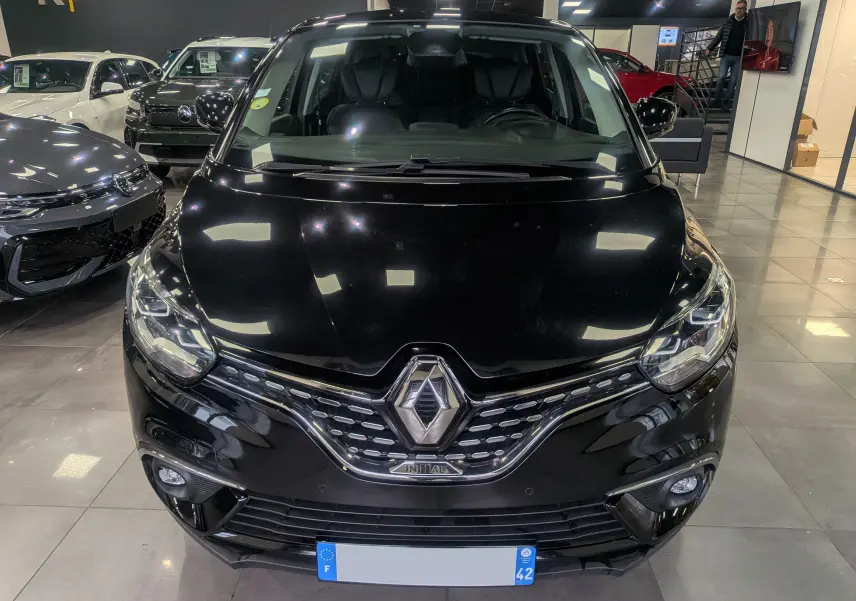 Vue de face d'un Renault Scénic IV noir étoilé, mettant en valeur sa calandre chromée et ses phares LED.