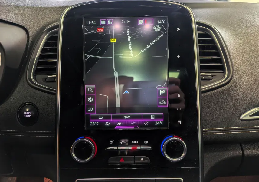 Vue intérieure du tableau de bord du Renault Scénic IV avec écran tactile de navigation et commandes climatisation.