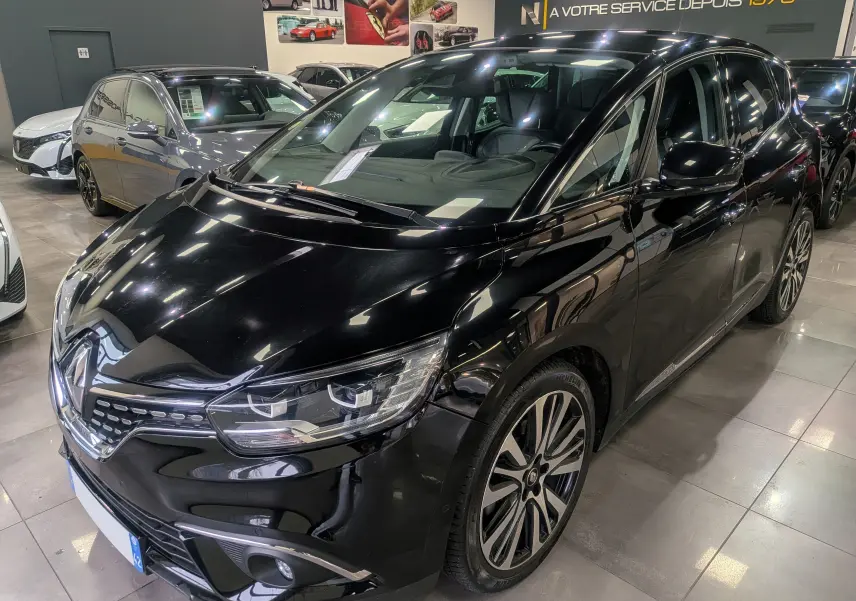Renault Scénic IV noir étoilé en 3/4 avant droit, avec jantes alliage bi-ton et phares LED visibles en showroom.