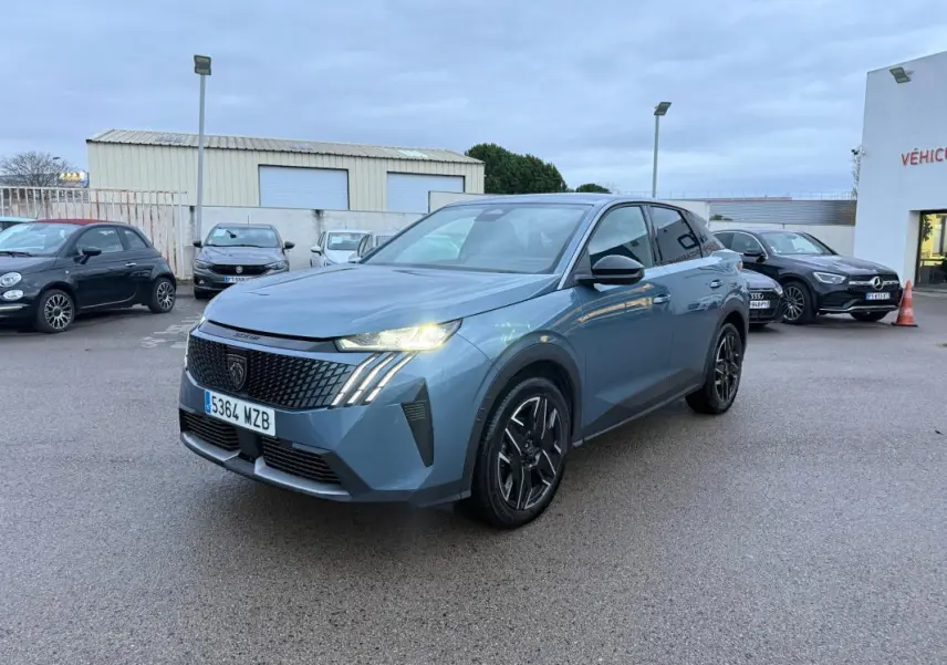 Peugeot 3008 Hybrid bleu en 3/4 avant droit, phares allumés et jantes alliage noires de 19 pouces visibles.