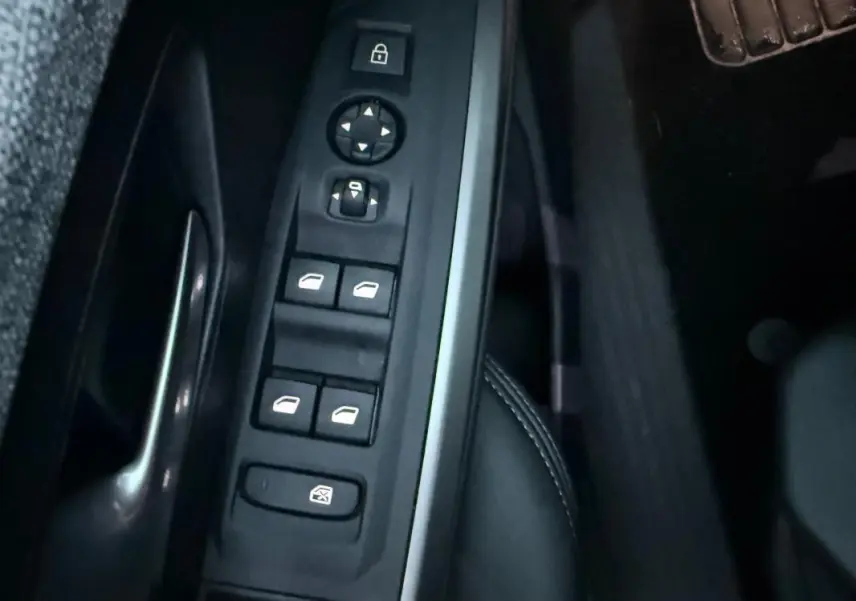 Vue rapprochée des commandes de lève-vitres et rétroviseurs côté conducteur du Peugeot 3008 Hybrid 145 e-DCS6 Allure.