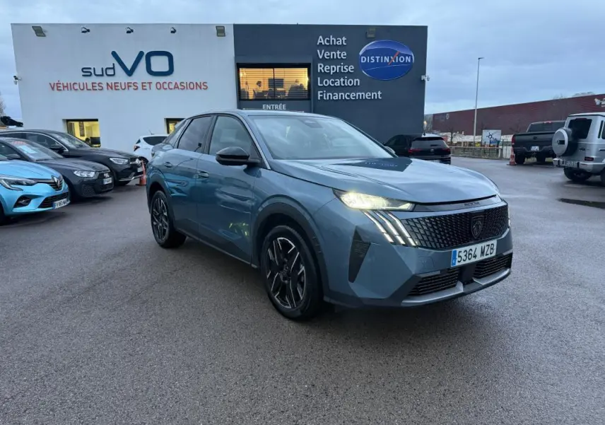 Peugeot 3008 Hybrid bleu vue 3/4 avant droit, feux allumés, jantes alliage 19 pouces, stationné devant un concessionnaire.