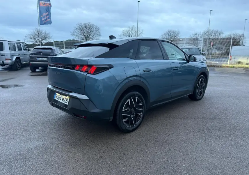 Peugeot 3008 Hybrid bleu en 3/4 arrière droit, jantes alliage 19 pouces et feux arrière LED allumés.