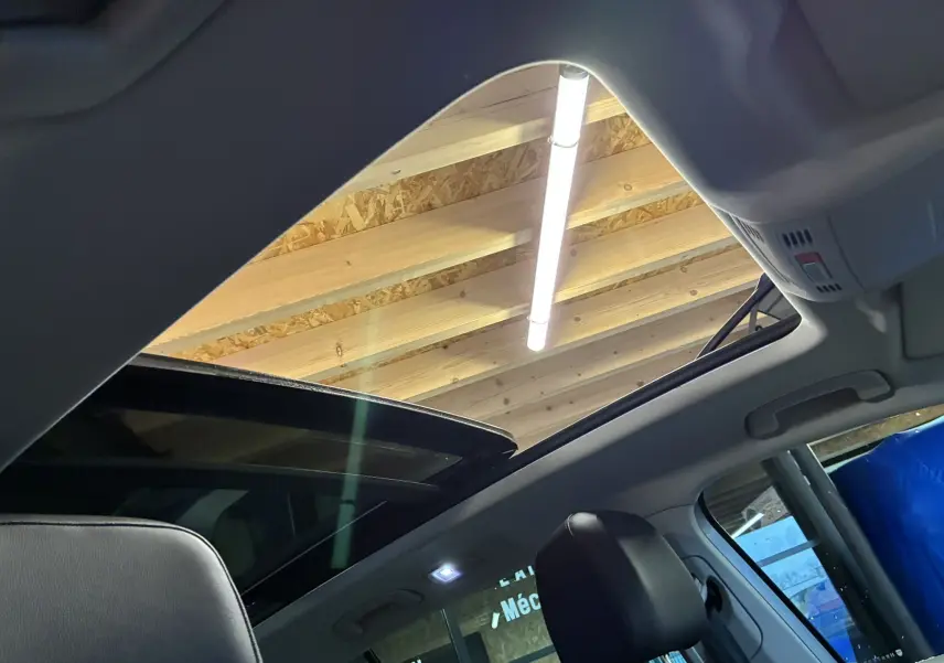 Vue intérieure du toit ouvrant panoramique du Volkswagen Tiguan gris 2017, avec sièges en cuir noir visibles.