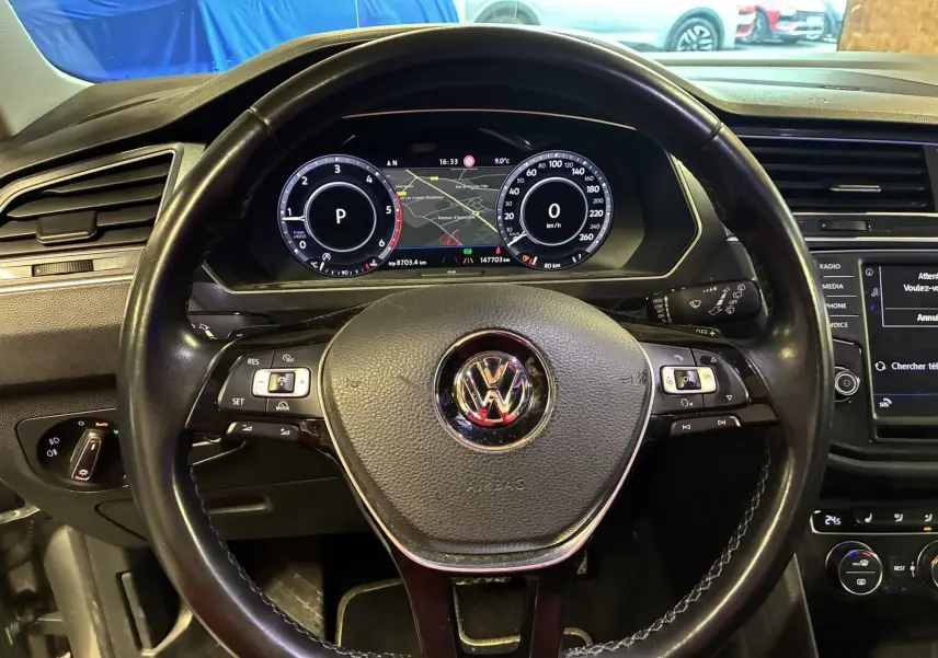 Vue rapprochée du volant noir en cuir et du tableau de bord numérique du Volkswagen Tiguan 2.0 TDI 150 Carat de 2017.