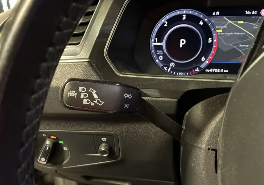 Vue rapprochée du combiné d'instruments et du commodo gauche du Volkswagen Tiguan gris 2017, avec affichage numérique et commandes éclairage.