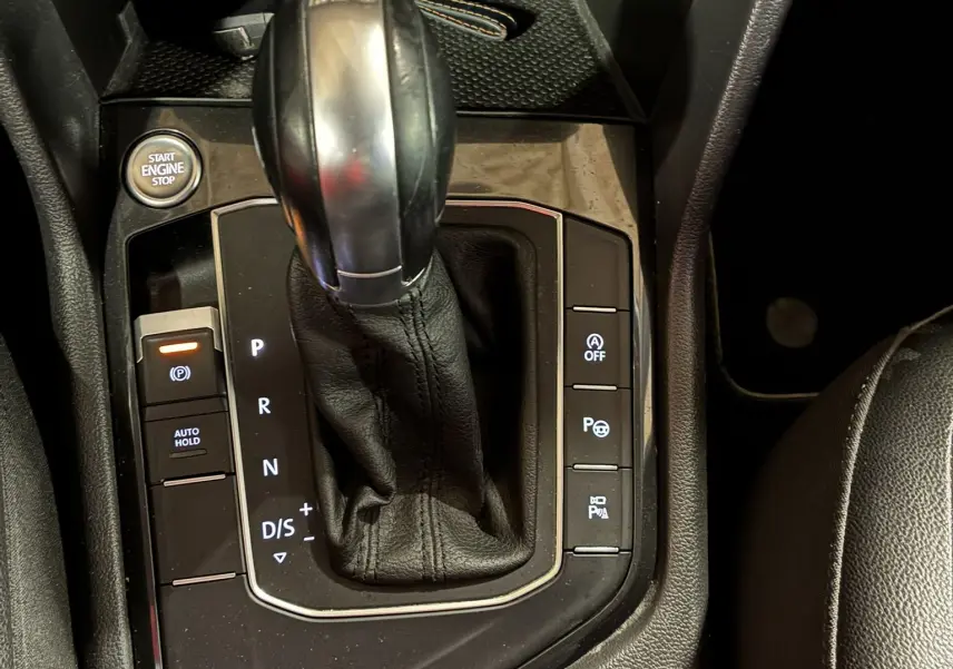 Vue rapprochée de la console centrale du Volkswagen Tiguan 2.0 TDI 150 Carat 2017, levier de vitesse automatique et boutons de commande.
