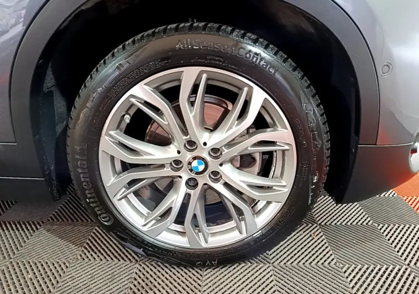 Gros plan sur la roue avant droite gris foncé d’un BMW X2 2021 avec jante alliage et pneu Continental AllSeasonContact.