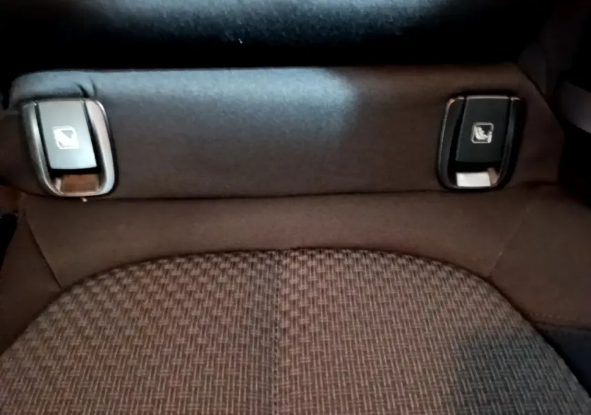 Détail des commandes de rabattement des sièges arrière sur banquette tissu gris foncé d'une BMW X2 sDrive18i Lounge.