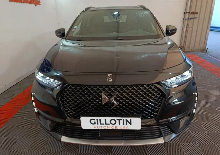 Vue avant du DS7 Crossback E-TENSE 4x4 300 noir brillant avec calandre distinctive et phares LED allumés.
