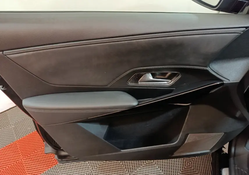 Gros plan sur la porte intérieure côté gauche du DS7 Crossback E-TENSE 4x4 300 Louvre noire, avec garniture cuir et poignée métal.