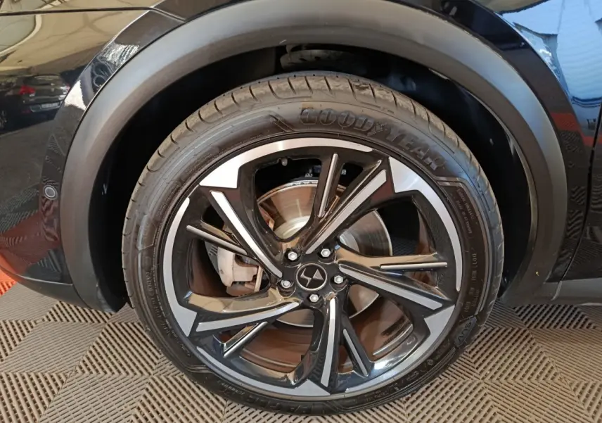 Gros plan sur la roue avant droite noire du DS7 Crossback E-TENSE 4x4 300 avec jante alliage bicolore.