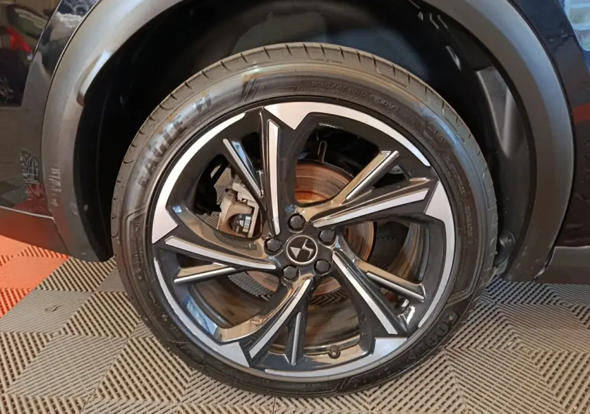 Gros plan sur la roue avant droite noire du DS7 Crossback E-TENSE 4x4 300 LOUVRE avec jante alliage bicolore.