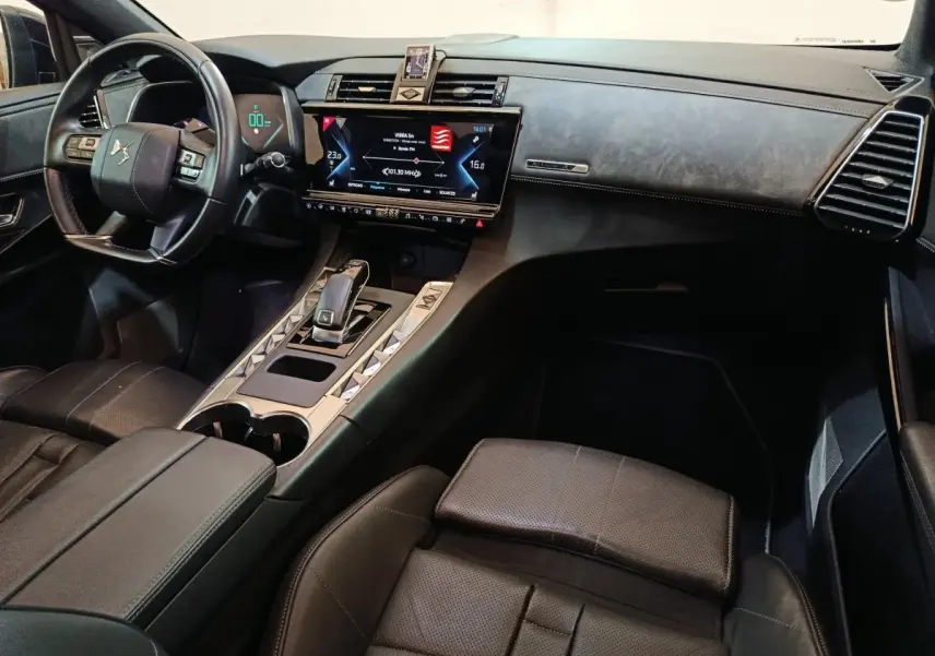Vue intérieure côté conducteur du DS7 Crossback noir, avec tableau de bord digital et écran tactile central lumineux.