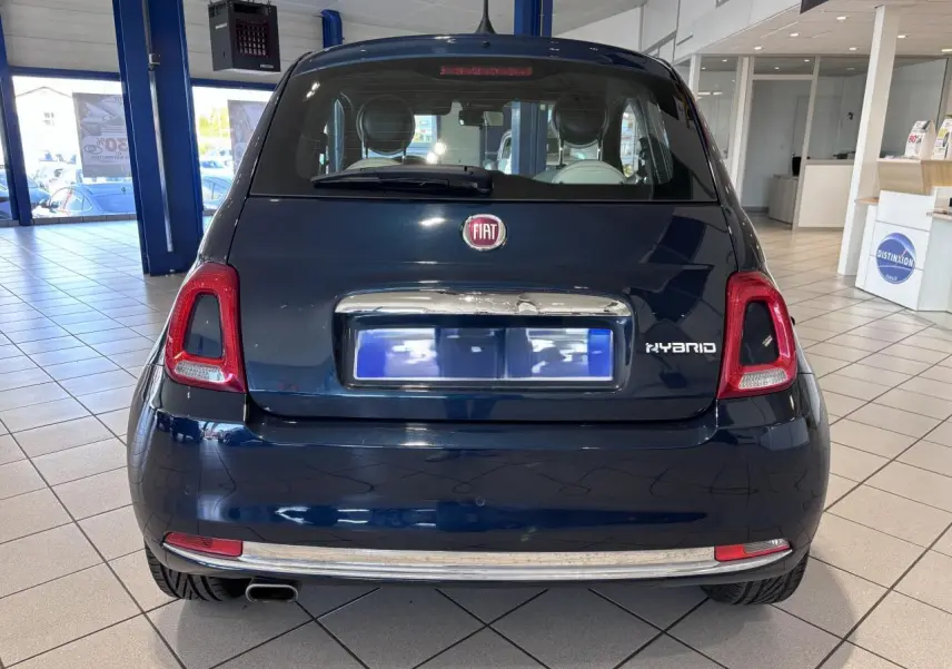 Vue arrière d'une Fiat 500 bleu foncé en showroom, avec logo Fiat et badge Hybrid visibles.
