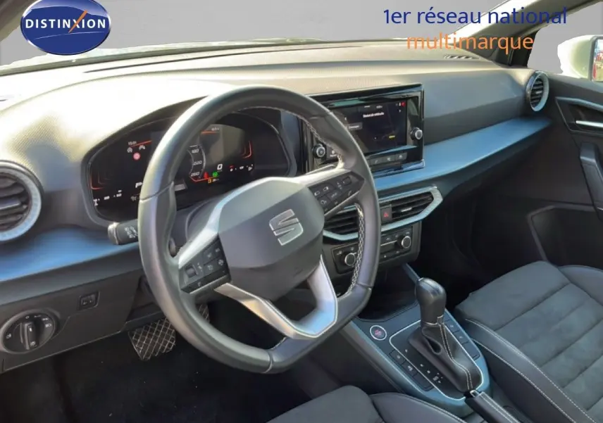 Vue intérieure du poste de conduite du SEAT Arona 2025, volant cuir multifonction et tableau de bord numérique.