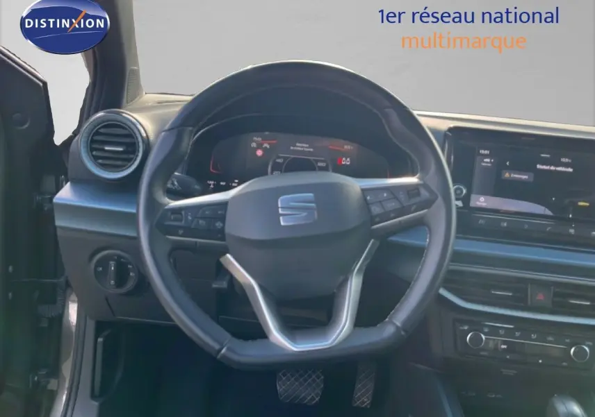 Vue intérieure centrée sur le volant cuir multifonction du SEAT Arona 2025, avec tableau de bord digital et écran tactile.